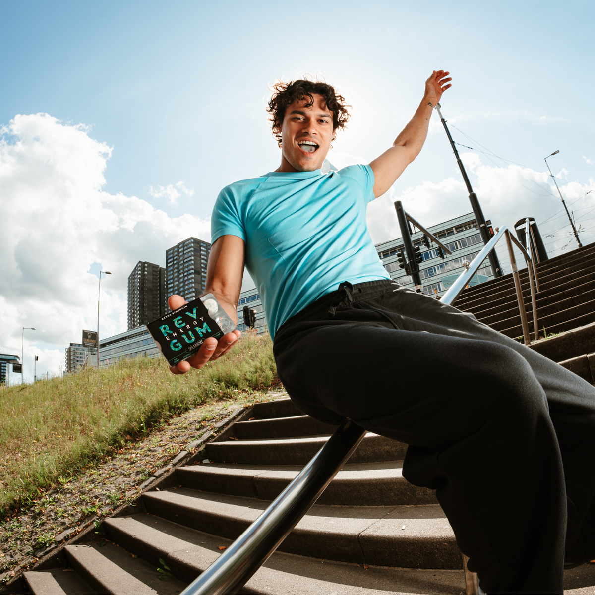 Person sitting on a railing outdoors displaying 'REV GUM'.